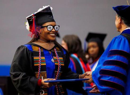 A 在线博彩 graduate with 2024 glasses accepts her degree